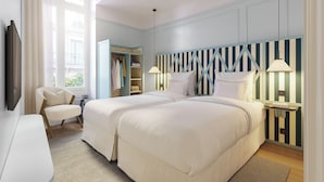 Een slaapkamer met twee bedden, een stoel, een nachtkastje, een lamp en een garderobe.