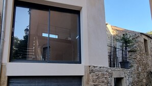 Een modern gebouw met een groot raam en een garagepoort.