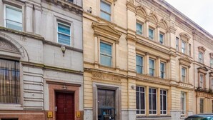 Een historisch gebouw met klassieke architectuur, met grote ramen en sierlijke details.
