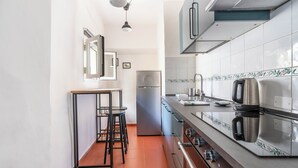 A kitchen with a stainless steel refrigerator, a coffee maker, and a tiled backsplash. - Pinzochere 16 N - Studio Apartment, Sleeps 2 (Firenze)