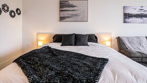 A neatly arranged bedroom with a large bed, two bedside lamps, a headboard, and a wall-mounted artwork. - Kissimmee Luxury 1BR Condo & Next to Disney World (Kissimmee)