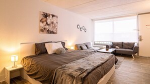 Un dormitorio con una cama grande, un sofá y una ventana.