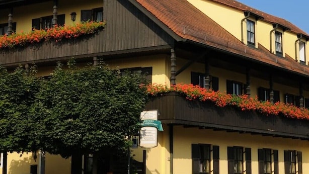 A traditional building with a steeply pitched roof, dormer windows, and flower boxes on the upper floor. - Boardinghouse calf stretcher (Altdorf)
