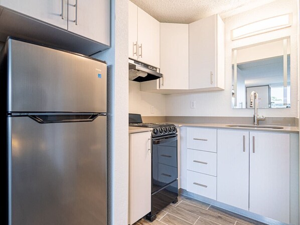 Refrigerador, cafetera/tetera, utensilios de cocina, mesa de comedor
