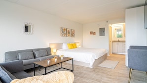 Ett modernt vardagsrum med en grå soffa, ett soffbord i trä och en mjuk, beige matta.
