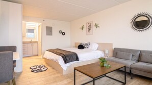 A modern bedroom with a bed, a sofa, a coffee table, and a desk.