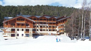 A large wooden lodge with multiple balconies and a ski slope in front. - travelski home classic - Résidence Les Balcons d'Anaïs 3* - 3 pièces 4/6 personnes (Villarodin-Bourget)