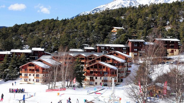 A ski resort with wooden cabins, a ski slope, and a mountain backdrop. - travelski home classic - Résidence Les Balcons d'Anaïs 3* - 3 pièces 4/6 personnes (Villarodin-Bourget)