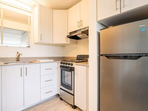 Fridge, coffee/tea maker, cookware/dishes/utensils, dining tables