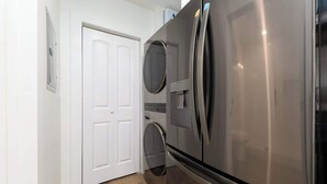 Eine Küche mit einem Edelstahl-Kühlschrank, einem Backofen mit zwei Türen und einer Waschmaschine.