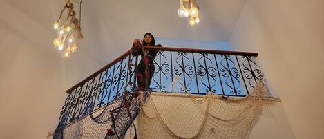 A staircase with a decorative railing and hanging lights.