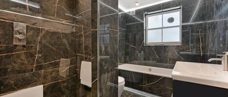A modern bathroom with a glass-enclosed shower, a bathtub, and a vanity with a mirror.