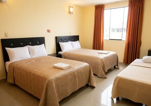 A hotel room with two beds, a window with curtains, and a light fixture on the wall. - Hotel Puerto Real Coatzacoalcos  (Coatzacoalcos)