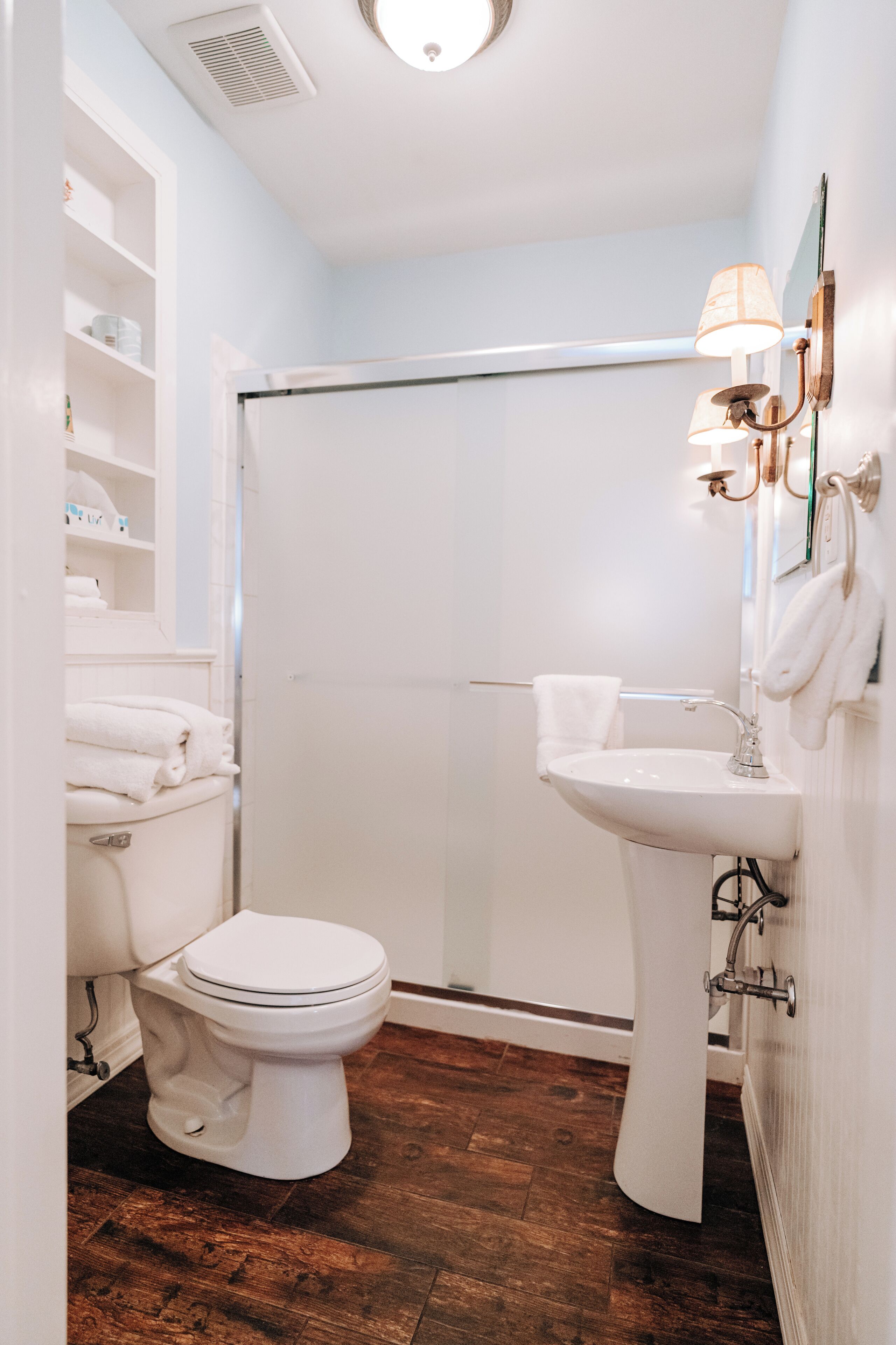 A bathroom with a toilet, sink, and shower.