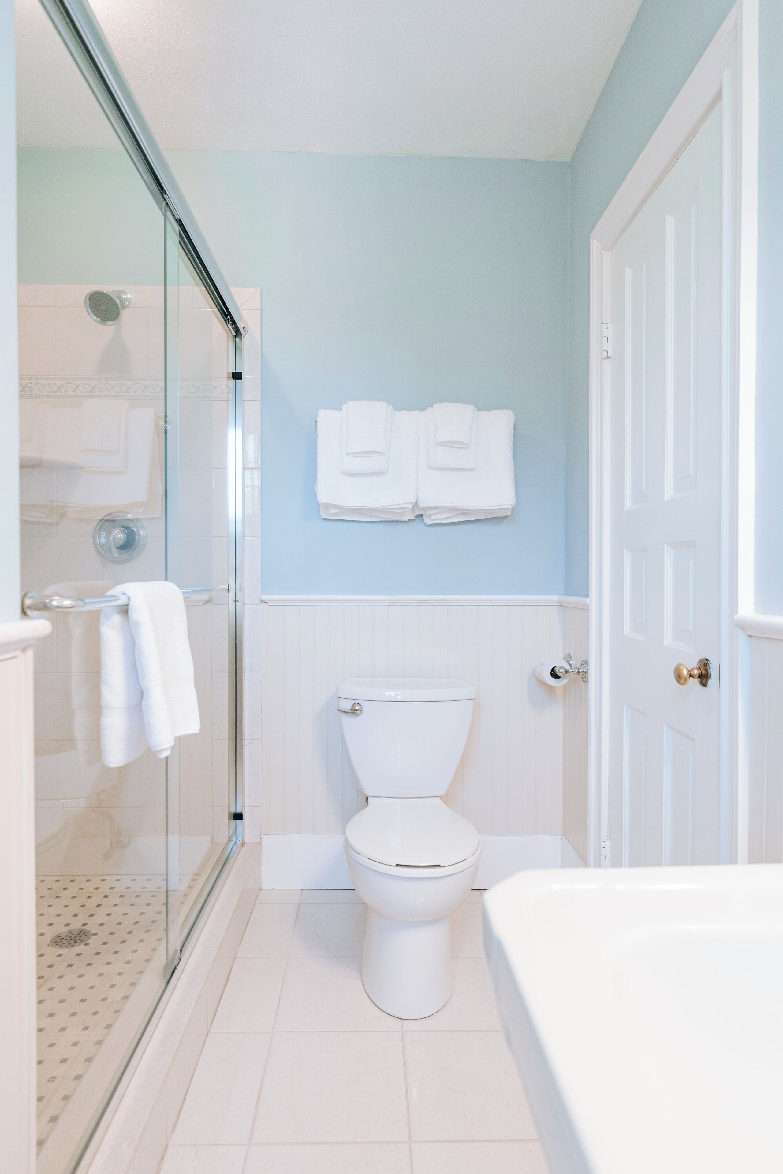 A bathroom with a glass-enclosed shower, a toilet, and a bathtub.