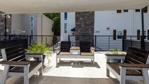 An outdoor seating area with wooden benches and potted plants. - Patio + Covered Terrace - Steps to TCU (Fort Worth)
