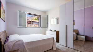 Una camera da letto con un letto, una cassettiera, uno specchio e un armadio.