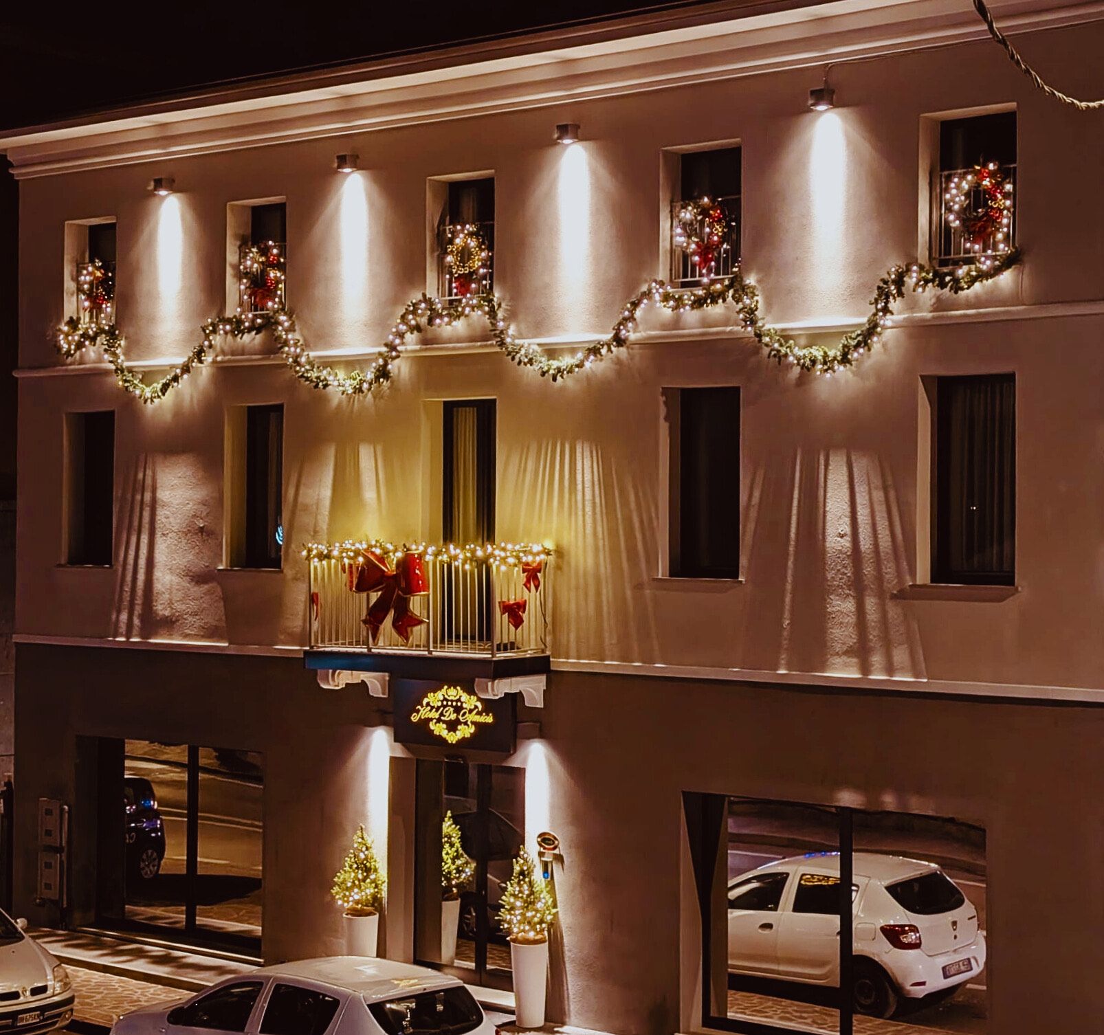 A hotel facade with multiple windows, some adorned with Christmas decorations.