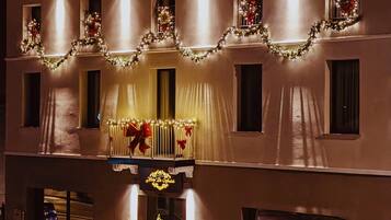 A hotel facade with multiple windows, some adorned with Christmas decorations.