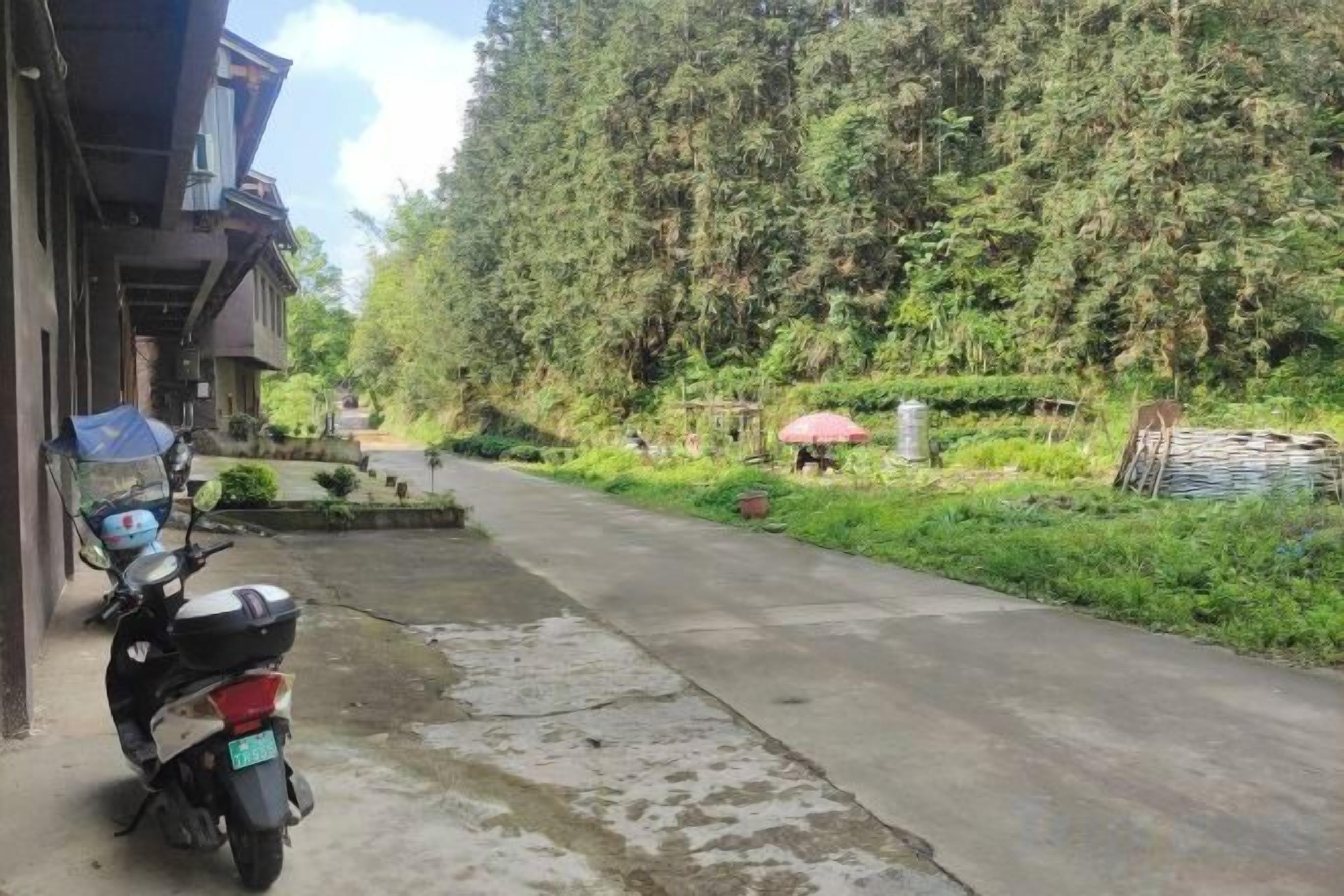 A paved path leading to a building with a parked scooter.