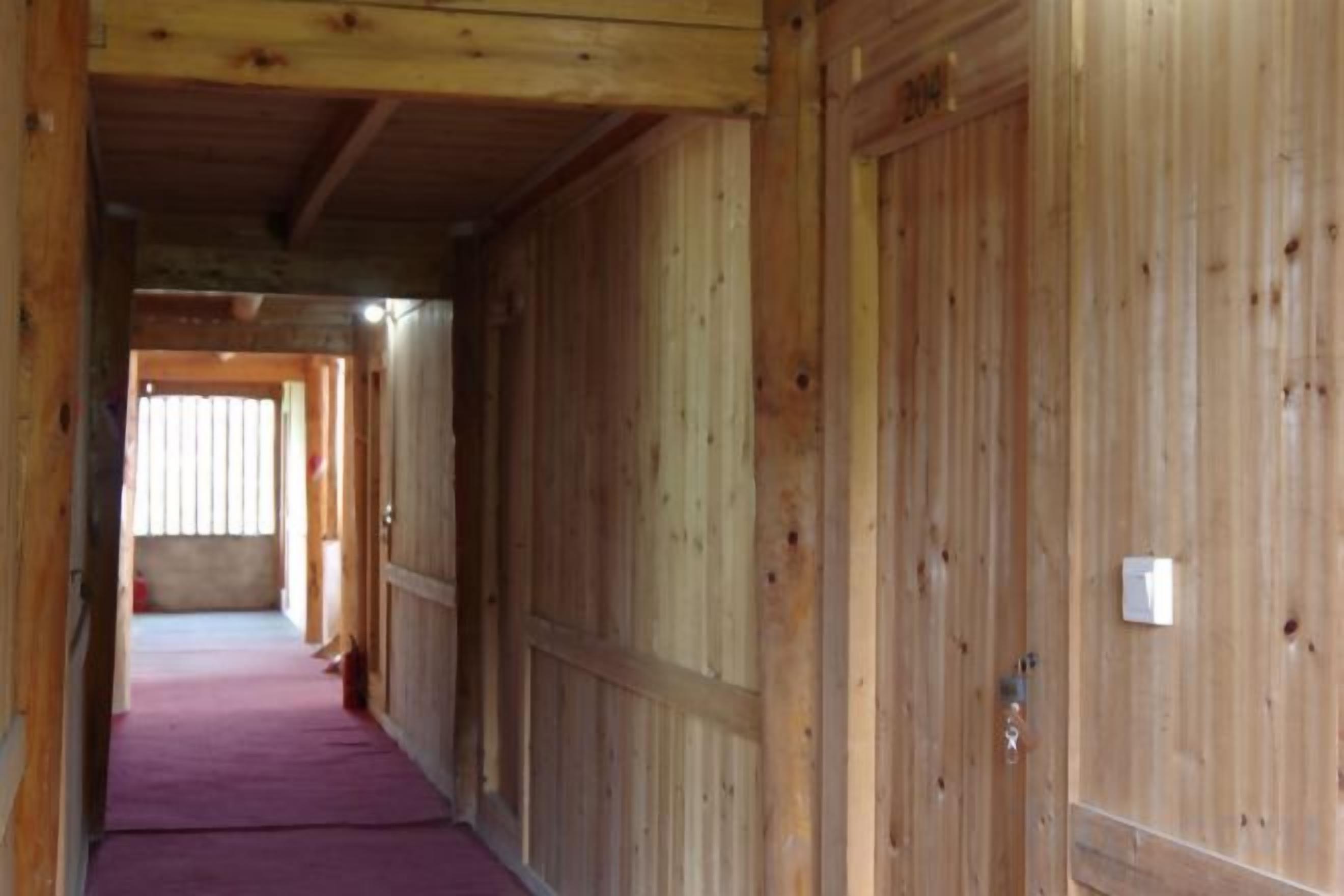 A corridor with wooden walls and a purple carpet.