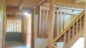 A wooden staircase with a handrail leading to an upper level. - Sanjiang Panjin Farmhouse (Sanjiang)