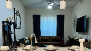A modern kitchen with a central island, stainless steel sink, and wooden cabinets. -  New! Luxury Midtown Escape (Houston)