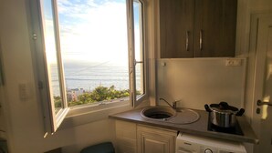 A small kitchen with a window, a sink, a stove, and cabinets. - Le rivage d'hélène - Apartment Sea view - 2 pers - 1 bedroom - All comfort (Ault)