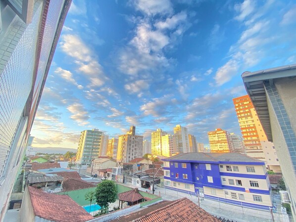 A cityscape with high-rise buildings, a mix of residential and commercial structures, and a clear sky with clouds.