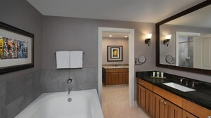 Une salle de bain moderne avec une baignoire, un meuble-lavabo et un grand miroir.