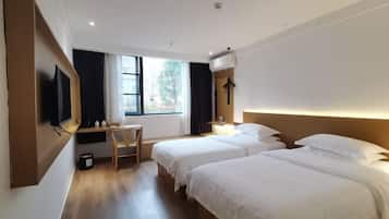 Quarto de hotel com duas camas, uma escrivaninha, uma cadeira e uma televisão.