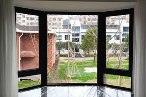 A corner room with a view of a residential area, including buildings and a grassy field. - Ruian Zhailiaoxi Hotel (Rui'an)
