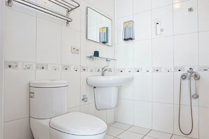 Une salle de bain avec des toilettes, un lavabo et une douche.