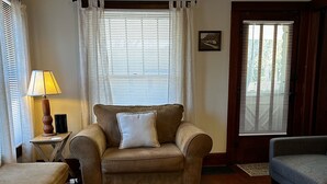 Ein Wohnzimmer mit einem braunen Sofa, einem blauen Sessel und einem Holztisch.