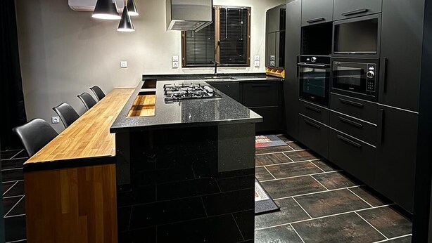 A modern kitchen with a central island, black cabinets, and stainless steel appliances. - Le Splendide !!!!! (Lévignacq)