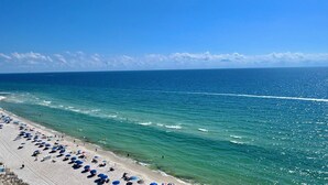 A beach with umbrellas and people. - Crystal Shores West 707 (Gulf Shores)