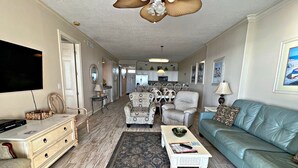 A living room with a television, a sofa, a coffee table, and a patterned rug. - Regency Isle 703 (Orange Beach)