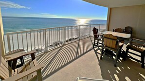 Un balcon avec vue sur l’océan, une table avec des chaises et une balustrade.
