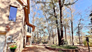 A two-story building with a brick facade, large windows, and a covered patio area with outdoor furniture. - Daphne River Villa (Daphne)