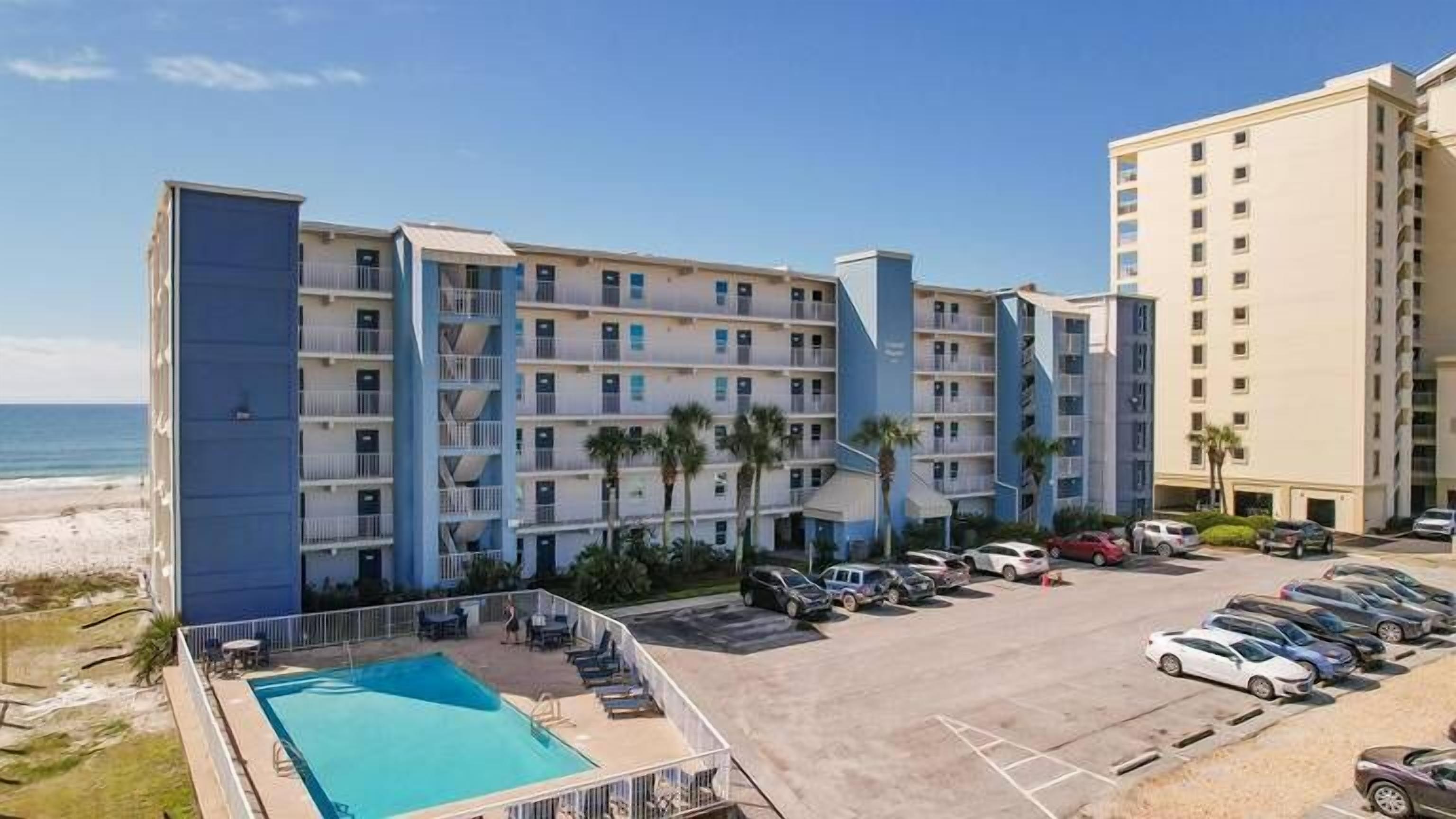 Un hôtel à plusieurs étages, doté d’une piscine et d’un parking.