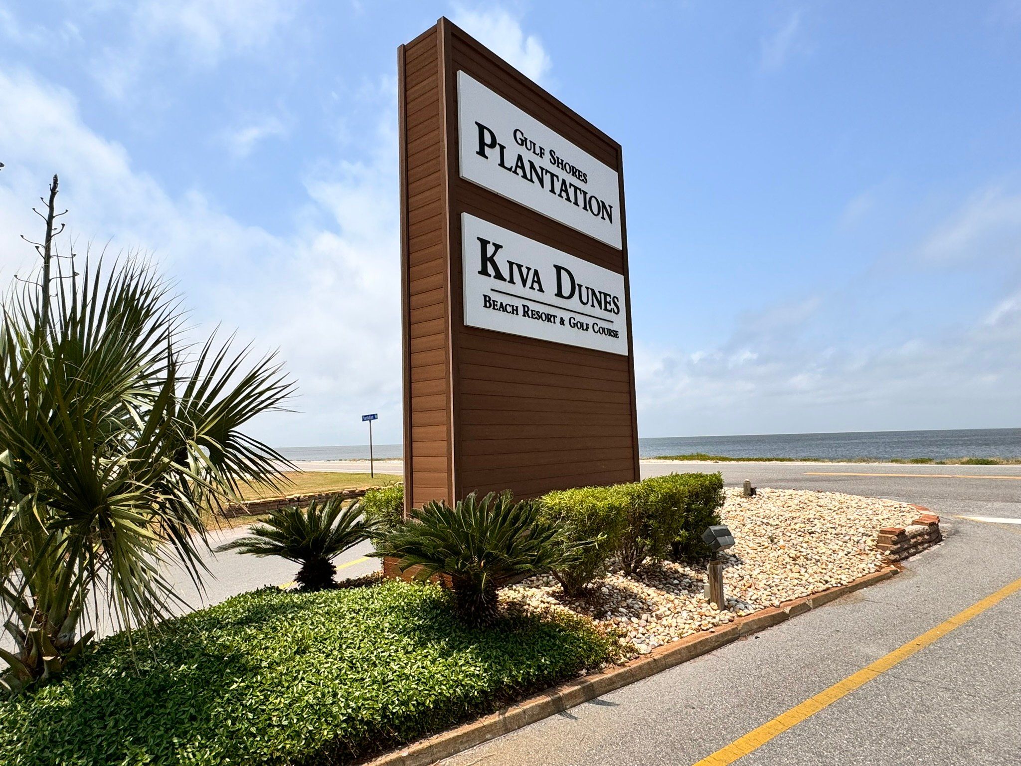 A sign for Kiva Dunes Beach Resort & Golf Course with a view of the beach and ocean.