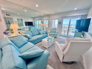 A spacious living room with a large sofa, a smaller armchair, a coffee table, and a television. - Gulf Shores Plantation (Gulf Shores)