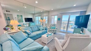 A spacious living room with a large sofa, a smaller armchair, a coffee table, and a television. - Gulf Shores Plantation (Gulf Shores)