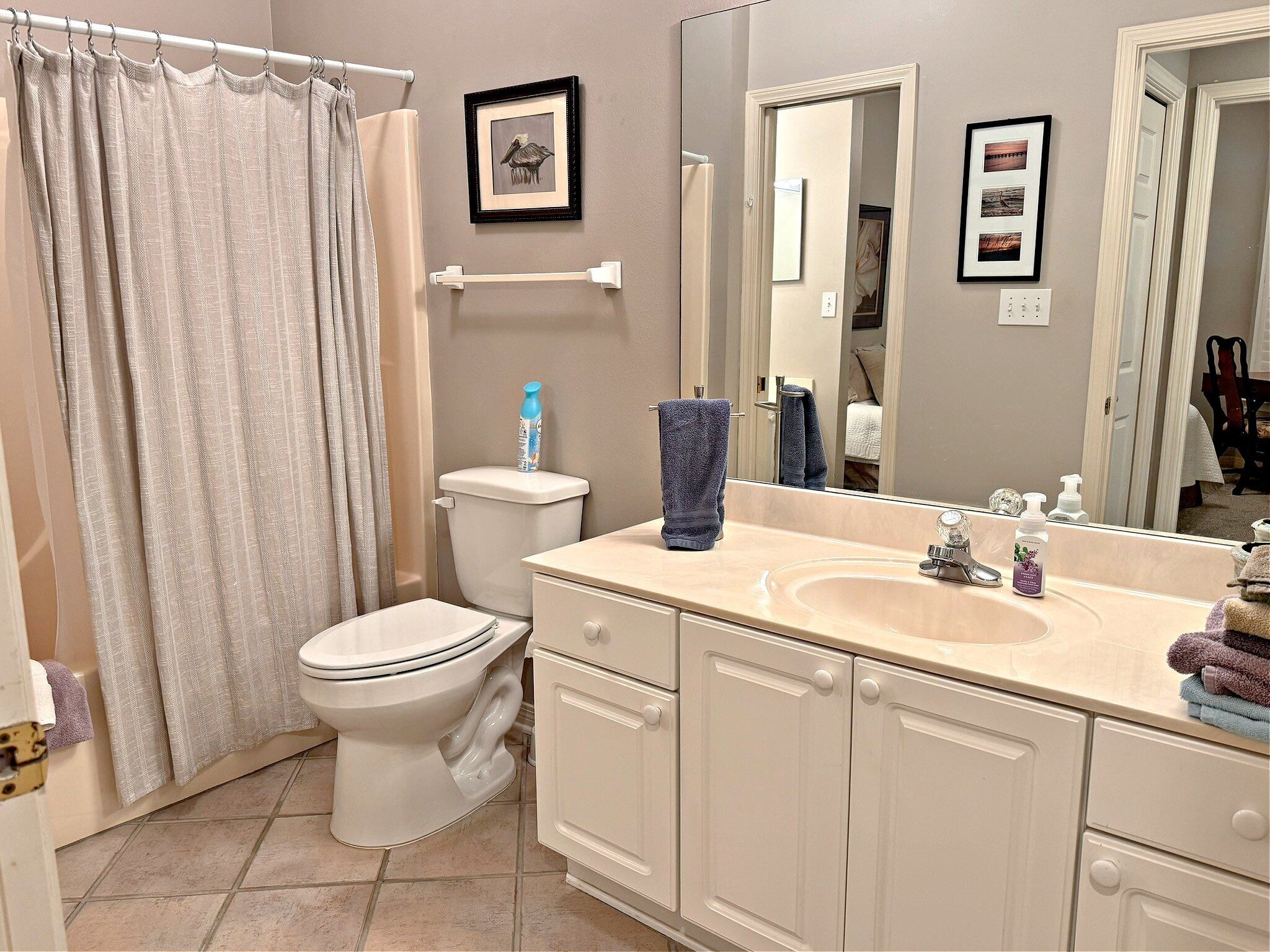 Une salle de bain avec des toilettes, un lavabo et un rideau de douche.