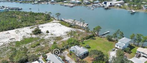 An aerial view of a coastal residential area with houses, docks, and a large body of water.