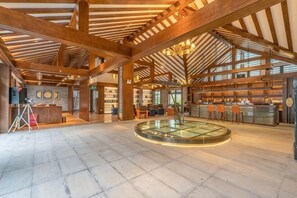 A spacious lobby with a central glass table, wooden beams, and a bar area. - Gongga cliff Hot Spring Hotel (Luding)