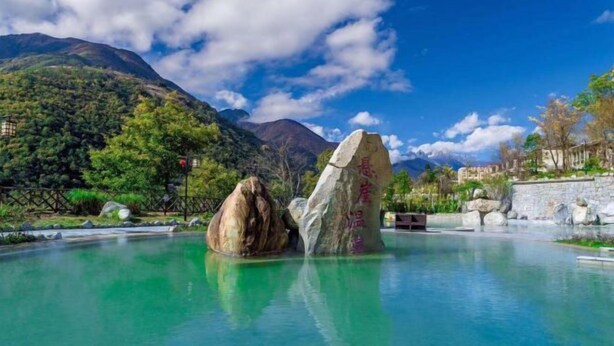 A serene pool area with large rocks and a mountain backdrop. - Gongga cliff Hot Spring Hotel (Luding)