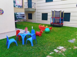 Guests can enjoy an outdoor play area with a table, chairs, a toy horse, a ball, and a slide.