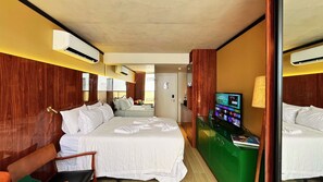 Une chambre d’hôtel avec un grand lit, un bureau avec un ordinateur et un miroir.