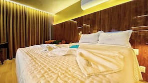 A hotel room with a large bed, wooden paneling, a desk, and a chair. - Setai Yacht Prime - By Almare (João Pessoa)